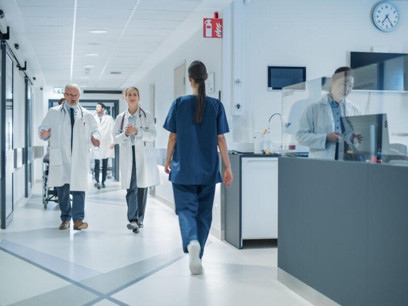 Diverse,Male,And,Female,Medical,Professionals,Walk,In,A,Busy